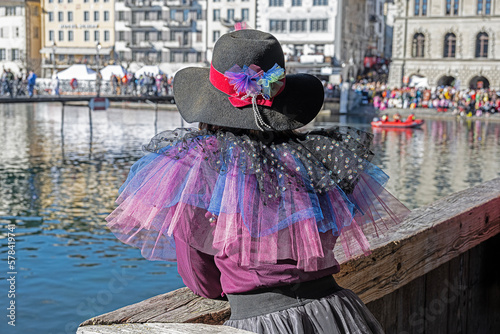 Frau in Fasnachtskostüme beobachtet auf der Kapellbrücke das Fasnachtsgeschehen, Luzern, Schweiz