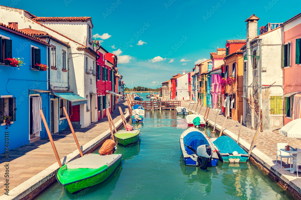 Burano, Italy with colorful painted houses along canal with boats