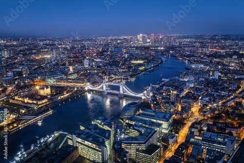 Elevated view of the illuminated skyline of London with Tower Bridge and Thames River during night time, England