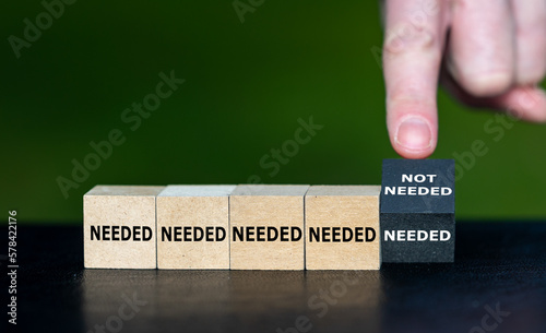 Needed and not needed. Hand turns cube and changes the expression 'needed' to 'not needed'.