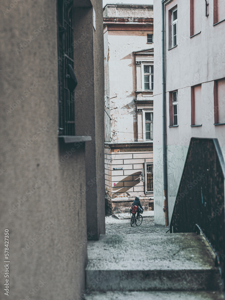 passage between tenement houses with person on bike