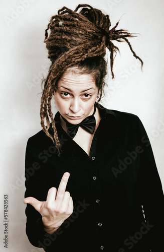 Girl with dreadlocks and bow tie showing middle finger up