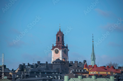 From south, the tower of the renovated church Stor Kyrkan, roofs and facades in the old town Gamla Stan, a sunny spring day in Stockholm
