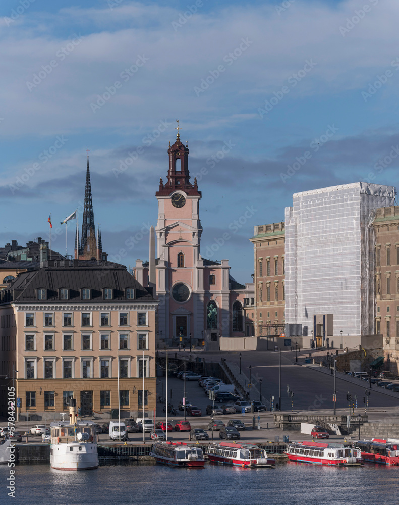 Naklejka premium The church Storkyrkan, the sloop Slottsbacken, the pier Skeppsbron with tourists and commuting boats. a sunny spring day in Stockholm