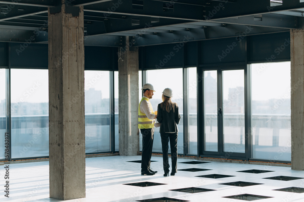 two architect engineers are walking in a constructed office building. implementation of the project two architect engineers are walking in a constructed office building. implementation of the project
