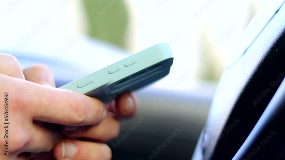 The young man is engaged in checking chats, e-mails and reading the news. The driver writes an SMS message in the car in social network chat rooms on a mobile phone. social media. The young man is engaged in checking chats, e-mails and reading the news. The driver writes an SMS message in the car in social network chat rooms on a mobile phone. social media.