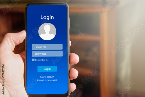 Foto Man Man holding mobile phone showing login interface on mobile phone screen, with username and password boxes and login button to access personal account in mobile application