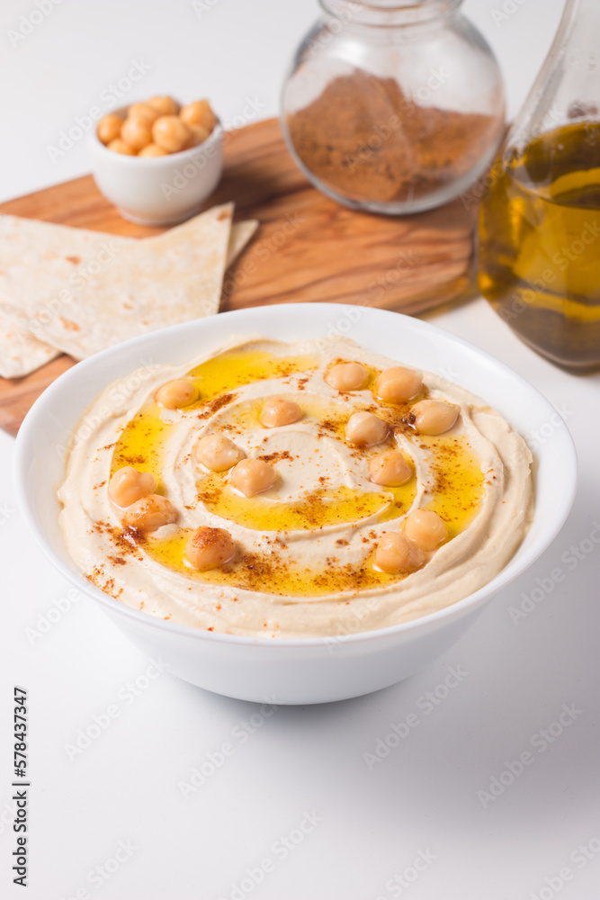 Hummus in a plate with chickpeas, smoked paprika, olive oil and pita. Vegetarian food.