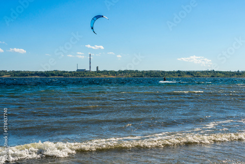 The kitesurfer enjoying beautiful sunny and wavy weather. Water sports. Leisure adrenaline activity photo