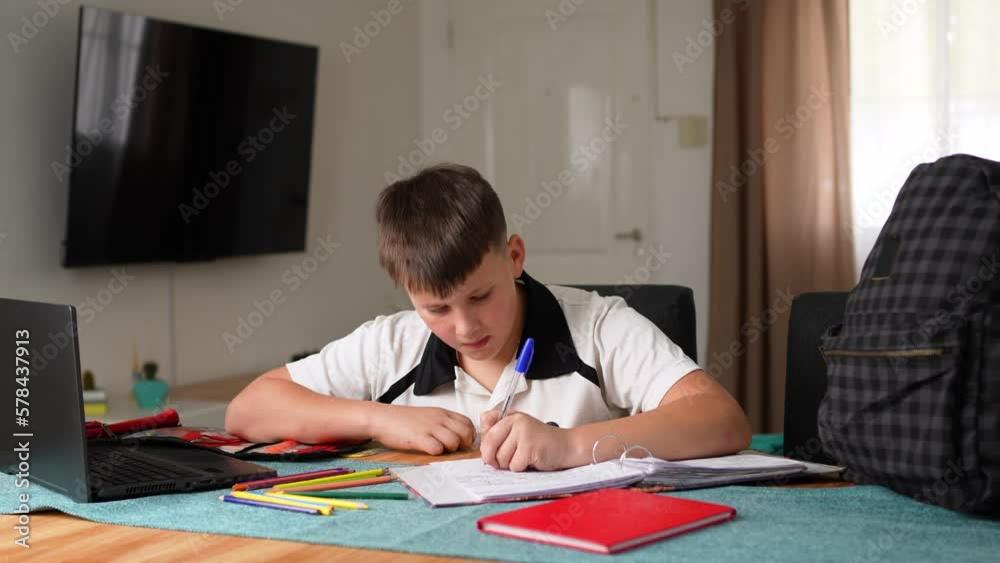 Kid doing homework while using his computer Kid doing homework while using his computer