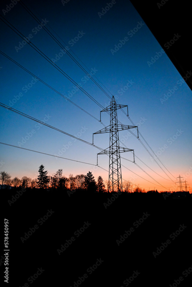 Sonnenuntergang mit einem Strommasten und Bäumen
