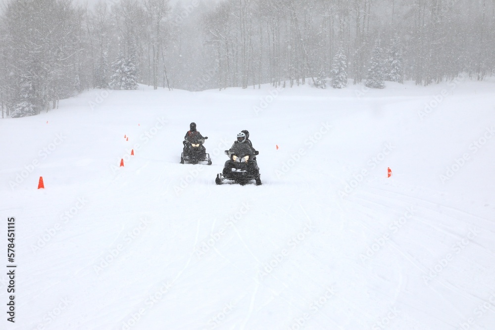 Snowmobile riders on the snowy trail