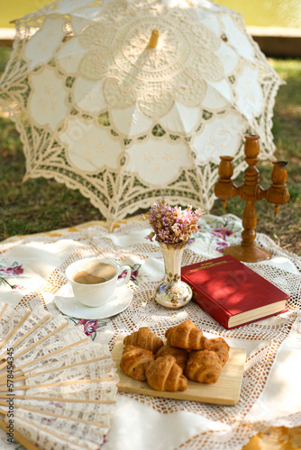 picnic in nature in summer with croissants, book and flowers