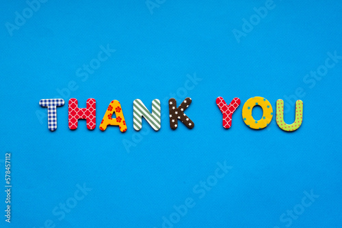 text thank you from bright colored paper letters on blue paper background