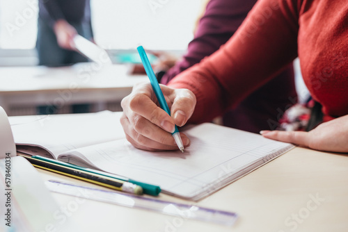 close up of a person writing on a notebook