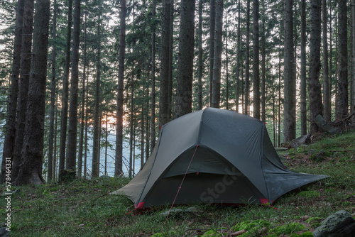 Lightweight freestanding three-season 2-person tent, inner tent body with rainfly, on forest in the evening in spruce forest in Beskid Mountains