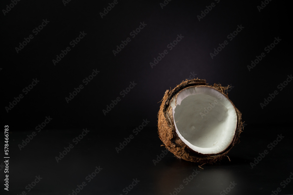 Cracked coconut on a black background. Copy space Cracked coconut on a black background. Copy space