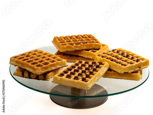 Chocolate waffles on a glass tray isolated on a white background. Wafers in chocolate. Close-up.
