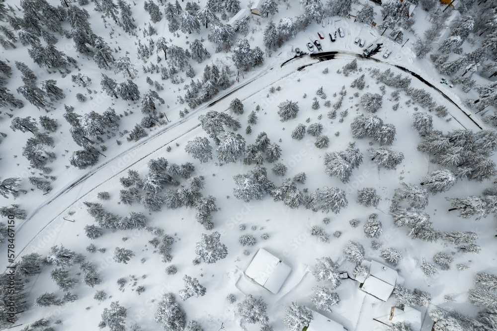 Drone scenery of car vehicles covered in snow on parked on a frozen road. Extreme weather snowstorm dangerous road. Troodos mountain Cyprus