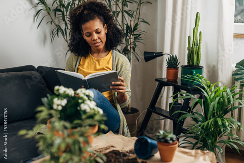 A mixed race woman s reading a book at home