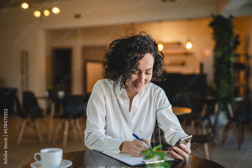 Fototapeta premium One woman mature female entrepreneur use smartphone phone at work
