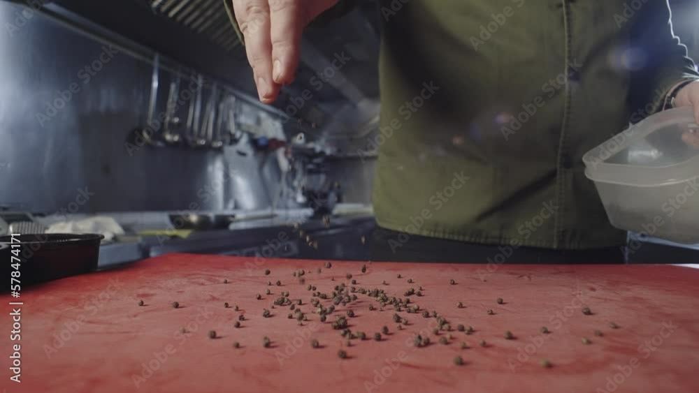 Chef pours black allspice on a blackboard in the kitchen. A professional prepares spices for meat. High quality 4k footage Chef pours black allspice on a blackboard in the kitchen. A professional prepares spices for meat. High quality 4k footage