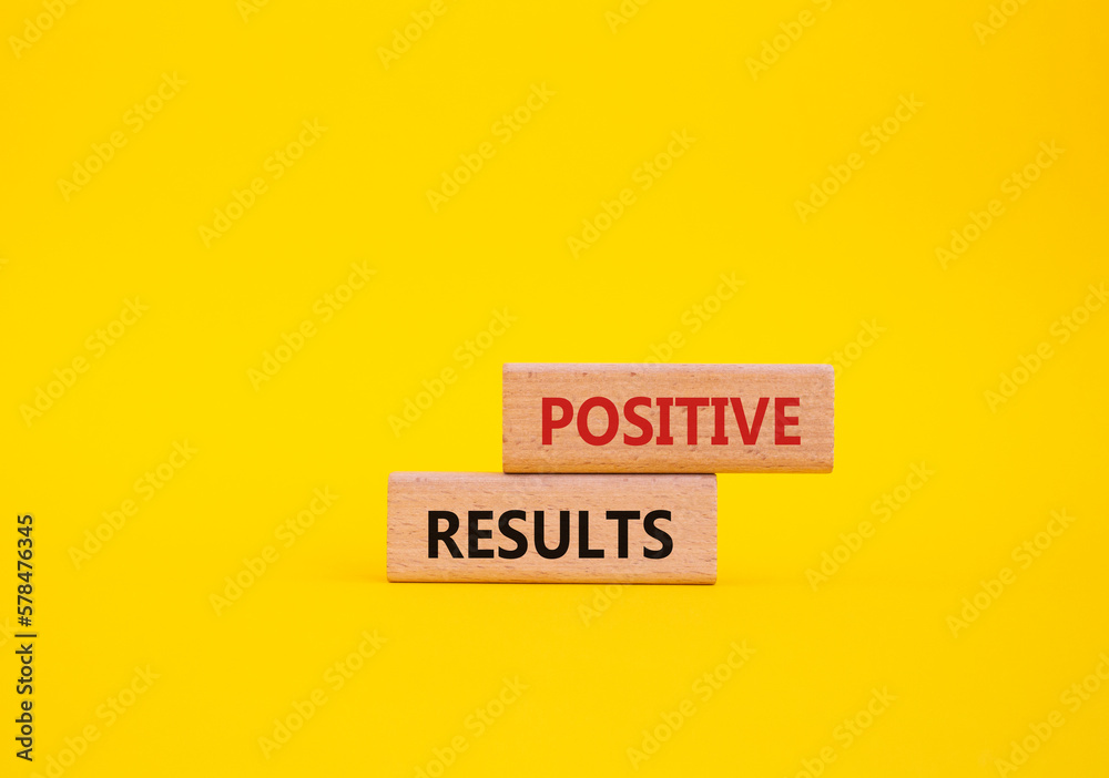 Positive results symbol. Concept words 'Positive results' on wooden blocks. Beautiful yellow background. Business and Positive results concept. Copy space.