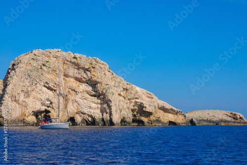 The blue limestone cave on the island of Bisevo in the Adriatic Sea. Tourists wait in front of the grotto in a white sailboat, Croatia.