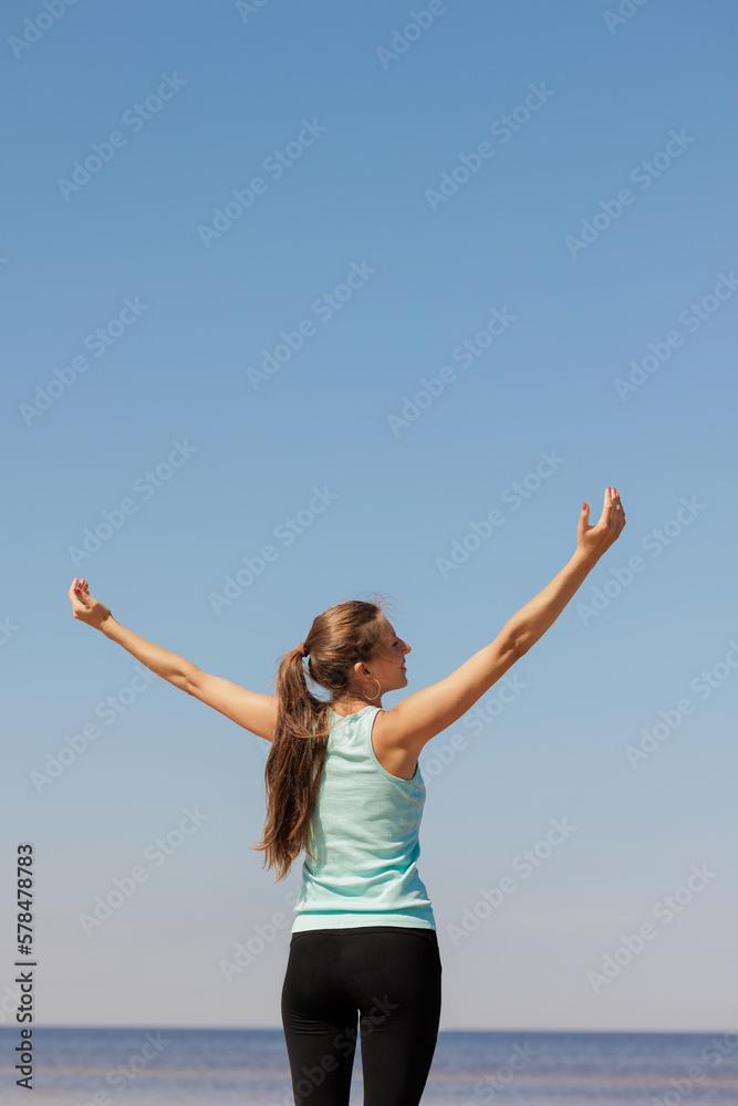 yoga and freedom, sporty woman does warm-up on seashore in morning with hands to sides. fitness millennial female trains, asana breathing practice, healthy lifestyle, love for your body, mental and yoga and freedom, sporty woman does warm-up on seashore in morning with hands to sides. fitness millennial female trains, asana breathing practice, healthy lifestyle, love for your body, mental and