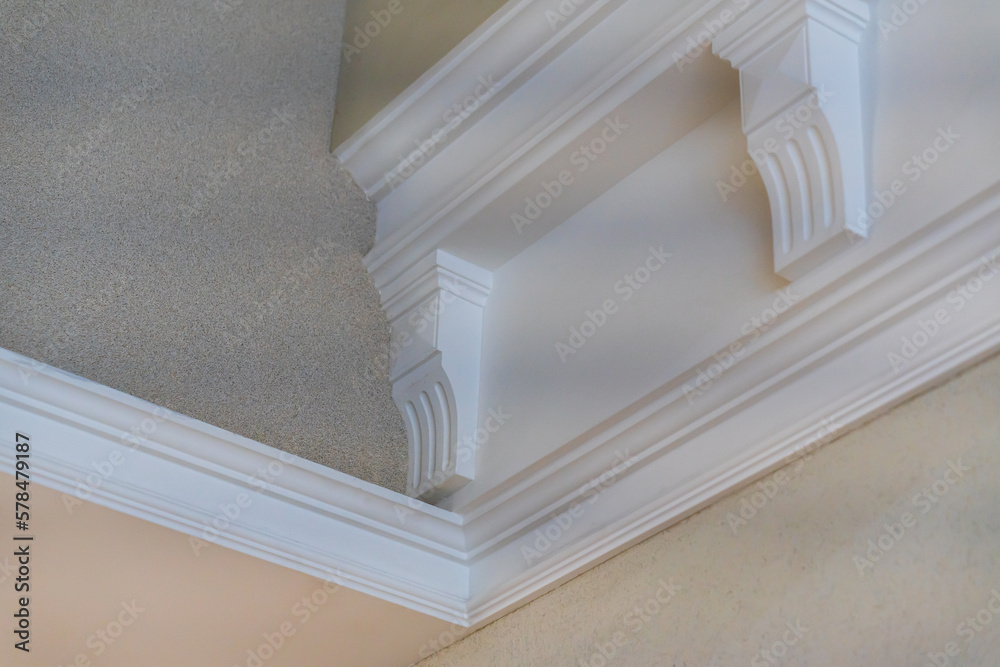 Obraz premium Ceiling moldings with an intricate crown in the inner corner. Home renovation, home decoration, real estate concept. White moldings on ceiling details. Interior design and architectural abstraction