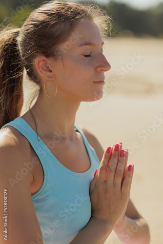 yoga, woman do meditation on seashore in morning. fitness millennial female trains, asana breathing practice hands in namaste, lotus pose, healthy lifestyle, love your body, mental physical condition