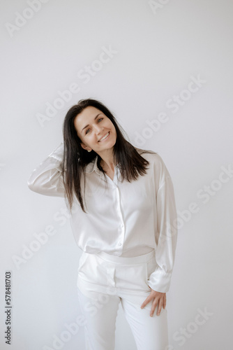 Dunkelhaarige Frau 35+, in weißem Hemd und weißer Hose