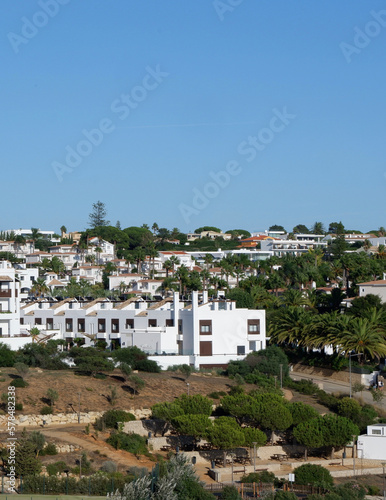 Holiday houses of white colour in the summer resort in Algarve, Portugal. Panoramic view from far. Verical photo © Yana Demenko
