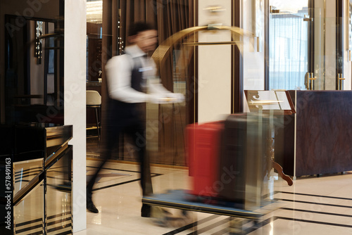 Photography Blurry motion of bellboy walking fast along lounge or hall of luxurious five sta