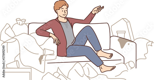 Man sit on sofa surrounded with trash