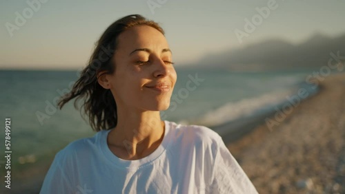 Outdoor portrait beautiful summer girl enjoying weekend at beach with mountains by the sea photo