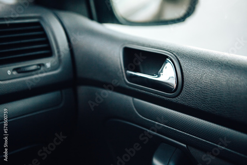 Close up door handle black dark car interior. Dashboard display panel. Climate control. Electric, hybrid elegant modern vehicle. Car detailing equipment.   © Volodymyr