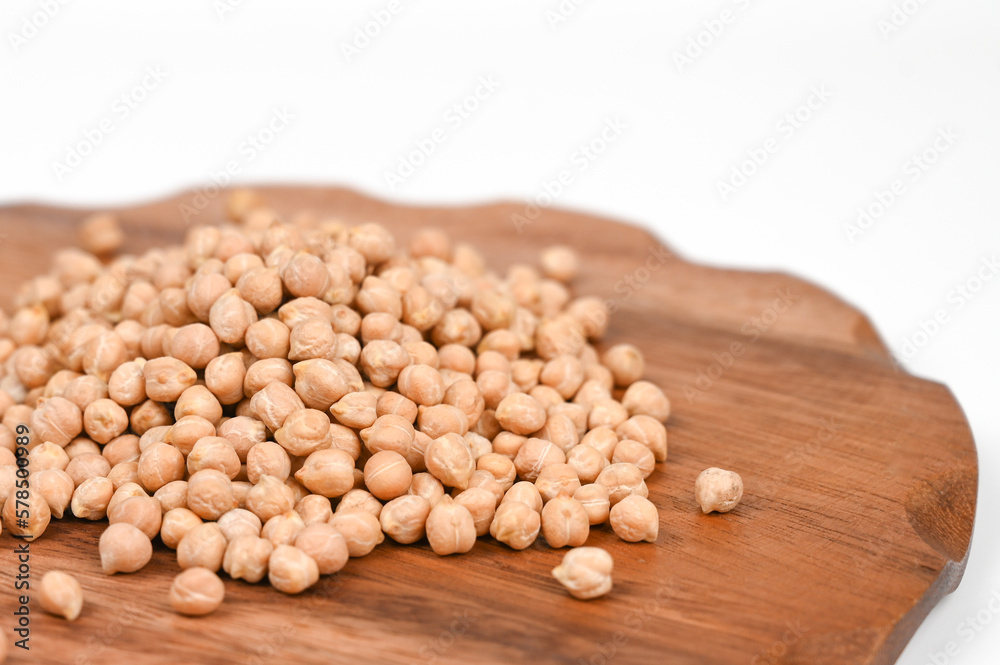 Scattered chickpea in a wooden plate, isolated on white backround