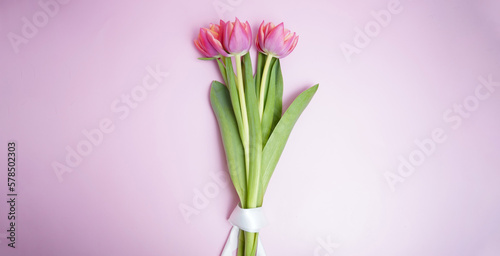 Bouquet of pink tulips flowers on pink background. Card for Mothers day, 8 March, Happy Easter. Waiting for spring. Greeting card or wedding invitation. Flat lay, top view
