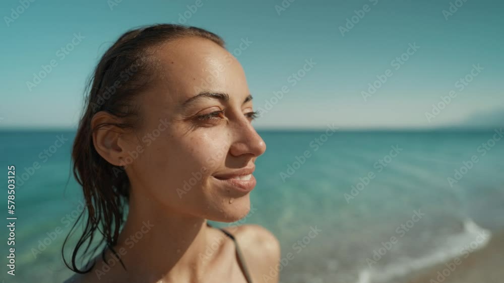 Outdoor shot of smiling young female model enjoying at sea beach against blue sky. Woman having fun out on a summer day. Outdoor shot of smiling young female model enjoying at sea beach against blue sky. Woman having fun out on a summer day.