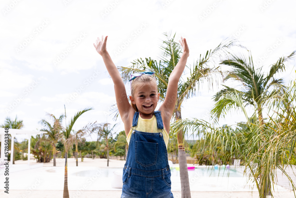 Portrait of happy biracial girl smiling by the swimming pool - obrazy, fototapety, plakaty 