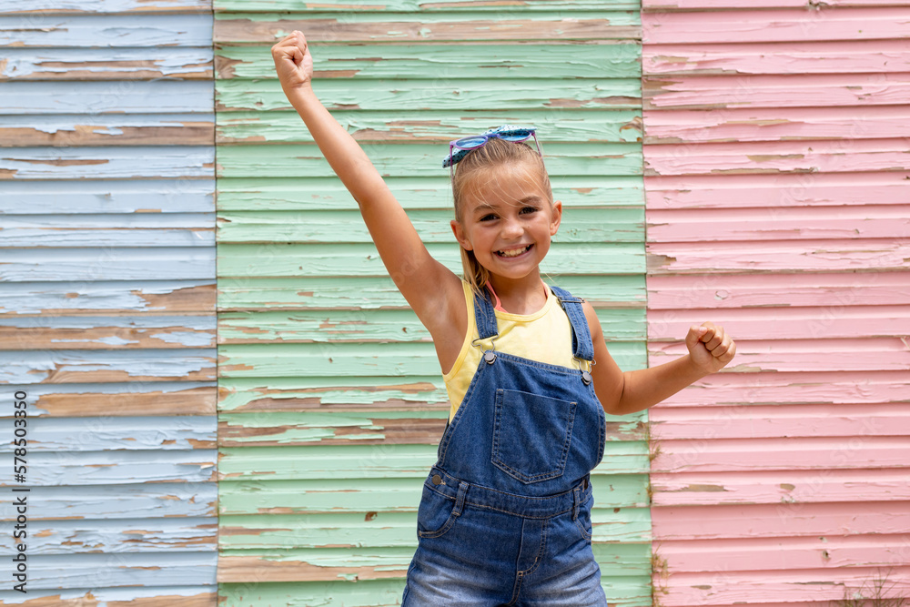 Portrait of happy biracial girl smiling over colorful wall - obrazy, fototapety, plakaty 