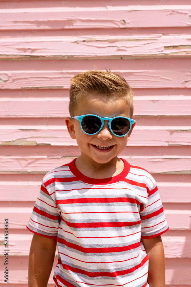 Portrait of happy biracial boy smiling over pink wall - obrazy, fototapety, plakaty 