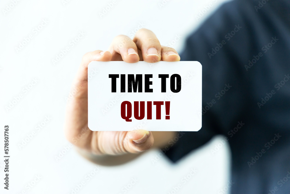 Time to quit text on blank business card being held by a woman's hand with blurred background. Business concept about the time to quit or stop bad habits or addiction. Time to quit text on blank business card being held by a woman's hand with blurred background. Business concept about the time to quit or stop bad habits or addiction.