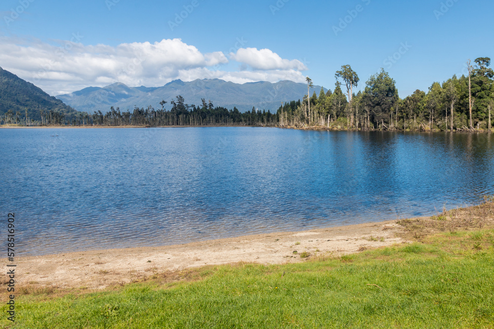 Lake Brunner (Moana) shoreline with Hohonu range and ancient podocarp trees in background, West Coast, South Island, New Zealand