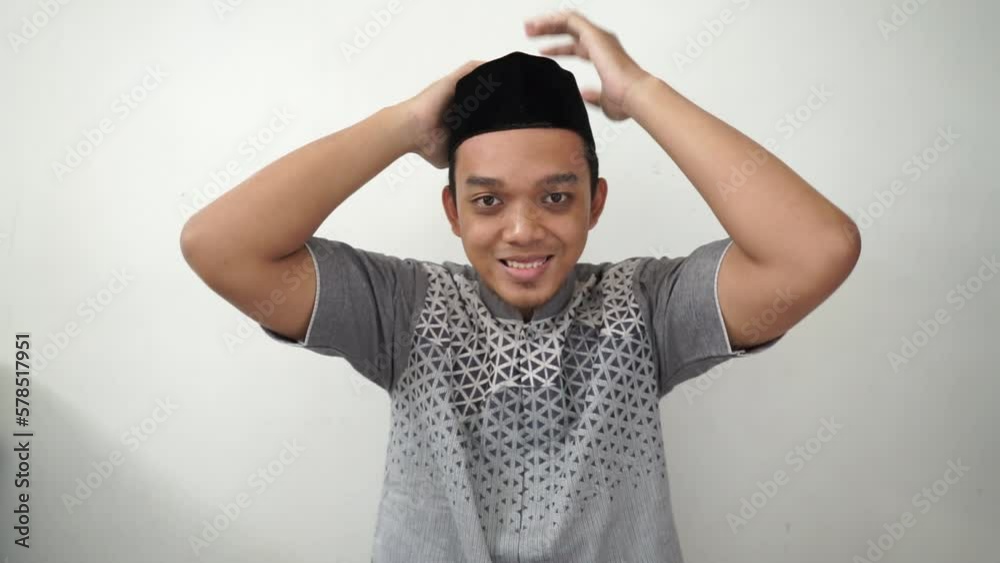 Indonesian Asian muslim man smiling wears black hat called peci or songkok