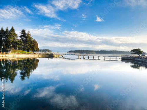 Panorama of Maffeo Suttun Park, reflection of clouds on water basin, whit a view of the pedestrian bridge.  photo