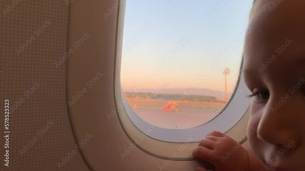 A little blonde boy looking through the porthole A little blonde boy looking through the porthole