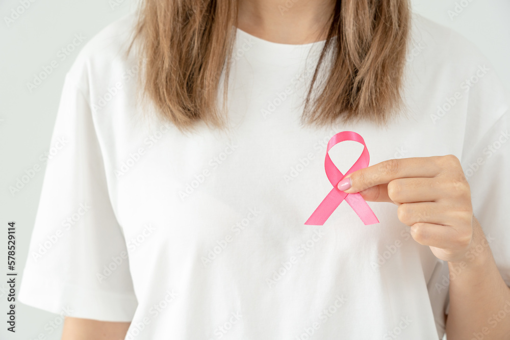 Woman hold pink ribbon breast cancer awareness. Female health check consciousness. international Women Day and World Cancer Day. sign cancer, Symbolic, health care, support patients, timely diagnosis Woman hold pink ribbon breast cancer awareness. Female health check consciousness. international Women Day and World Cancer Day. sign cancer, Symbolic, health care, support patients, timely diagnosis