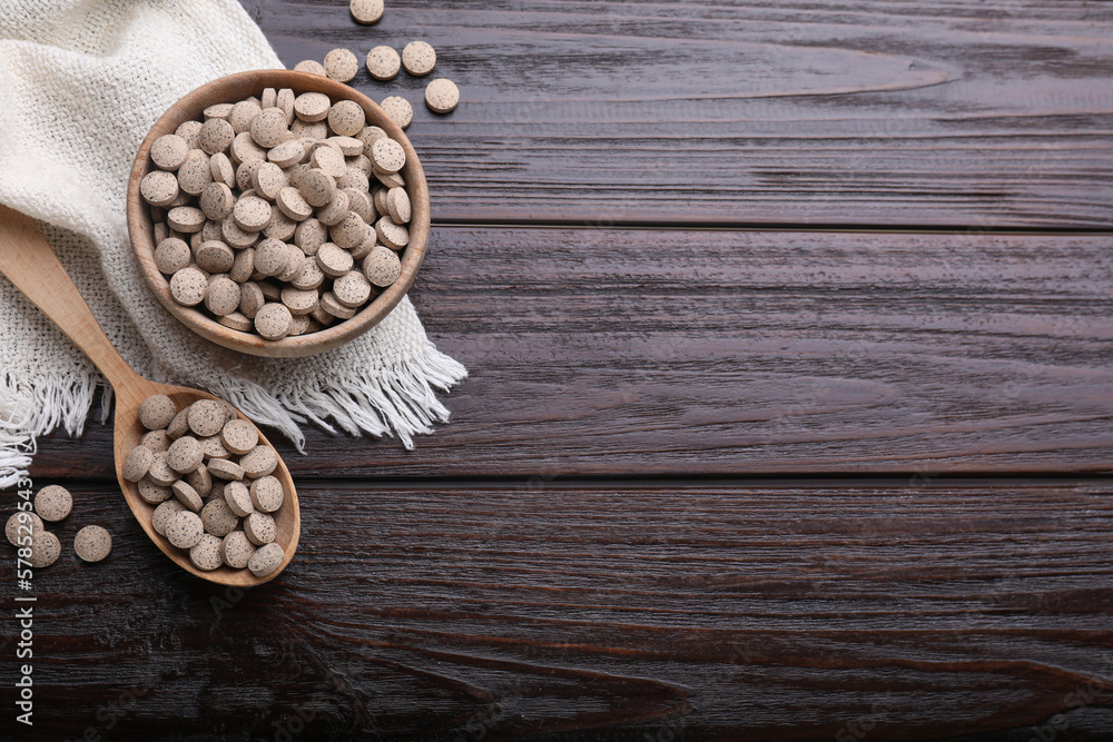 Flat lay composition with brewer`s yeast tablets on wooden table. Space for text Flat lay composition with brewer`s yeast tablets on wooden table. Space for text
